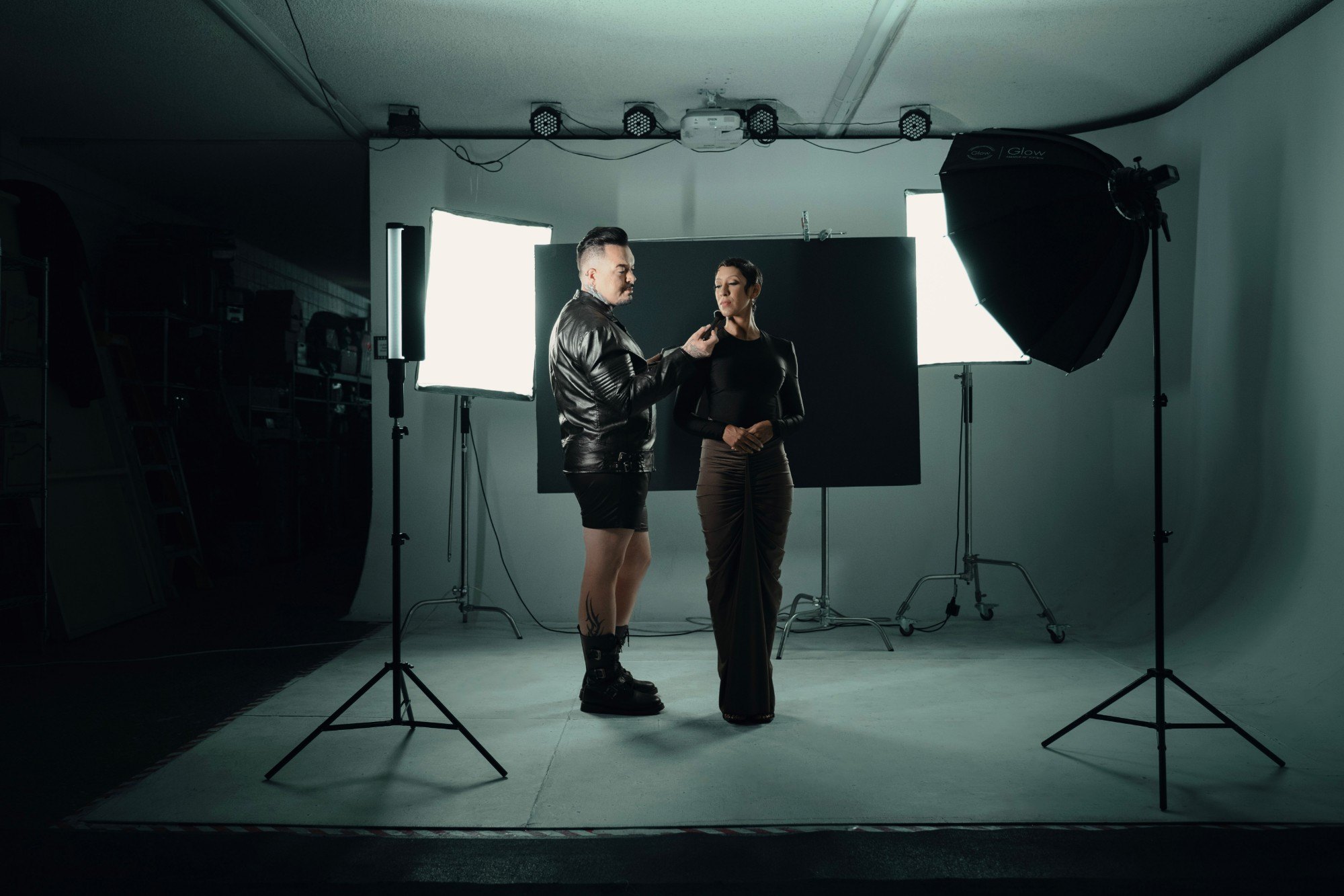 Ashley Nicole Singleton on a studio set under softbox lighting, a stylist adjusting her look between takes