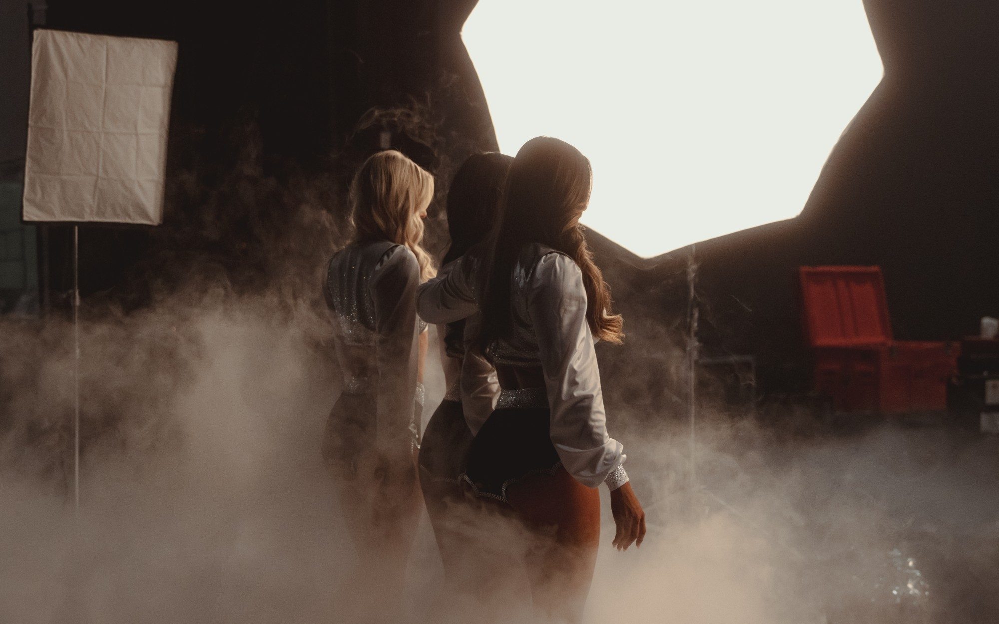 Raiderettes backlit in fog on the calendar shoot set
